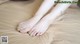 A woman's feet with green nail polish on a bed.