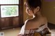 A woman in a kimono sitting in front of a window.