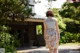 A woman walking down a path in front of a house.