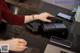 A woman is using a telephone at a desk.