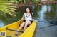 A woman sitting in a yellow kayak on a lake.