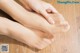 A woman's feet with a pair of stockings on a wooden floor.