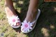 A pair of white sandals with pink flowers on them.