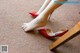 A woman's feet in red high heels on the floor.