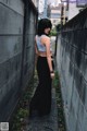 A woman standing in front of a concrete wall.